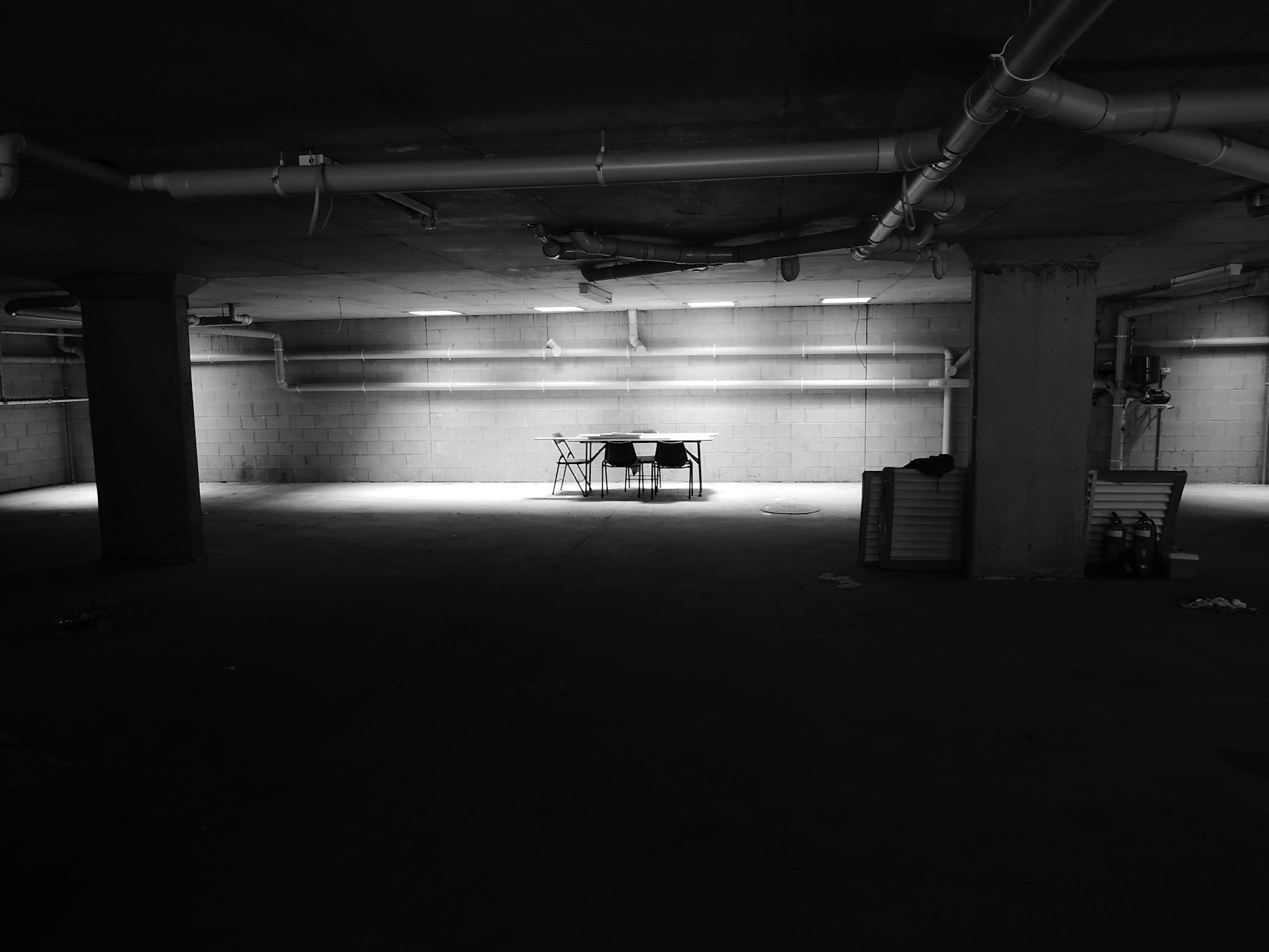 An empty, low-lit basement workspace with a single table — the room where the calls are reviewed