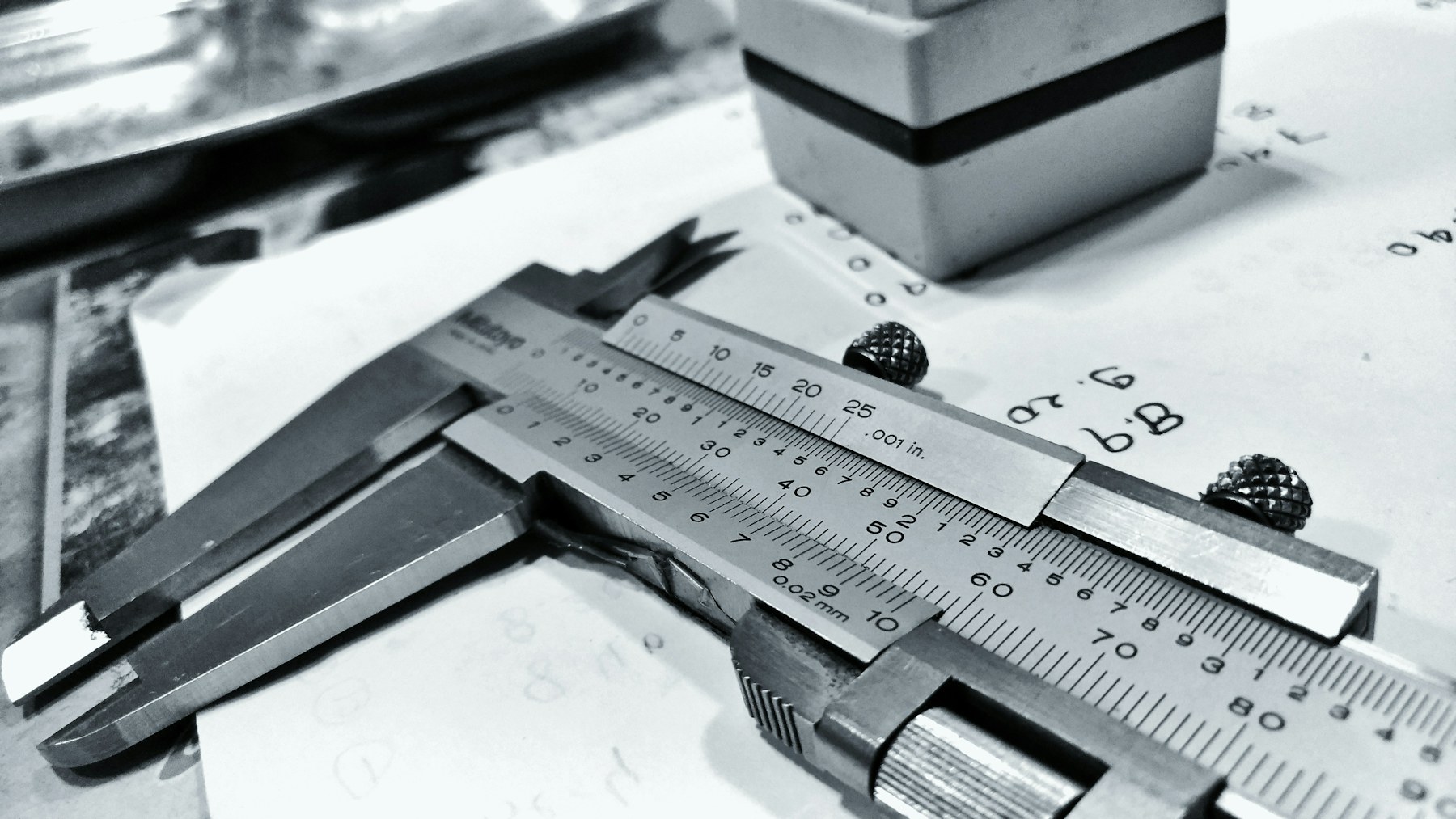 Dial caliper resting on a drawing — quality control as quiet ritual